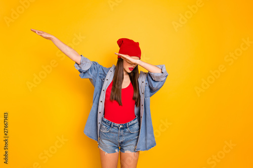 Portrait of cute teenager hide face raise hands isolated over yellow bright background