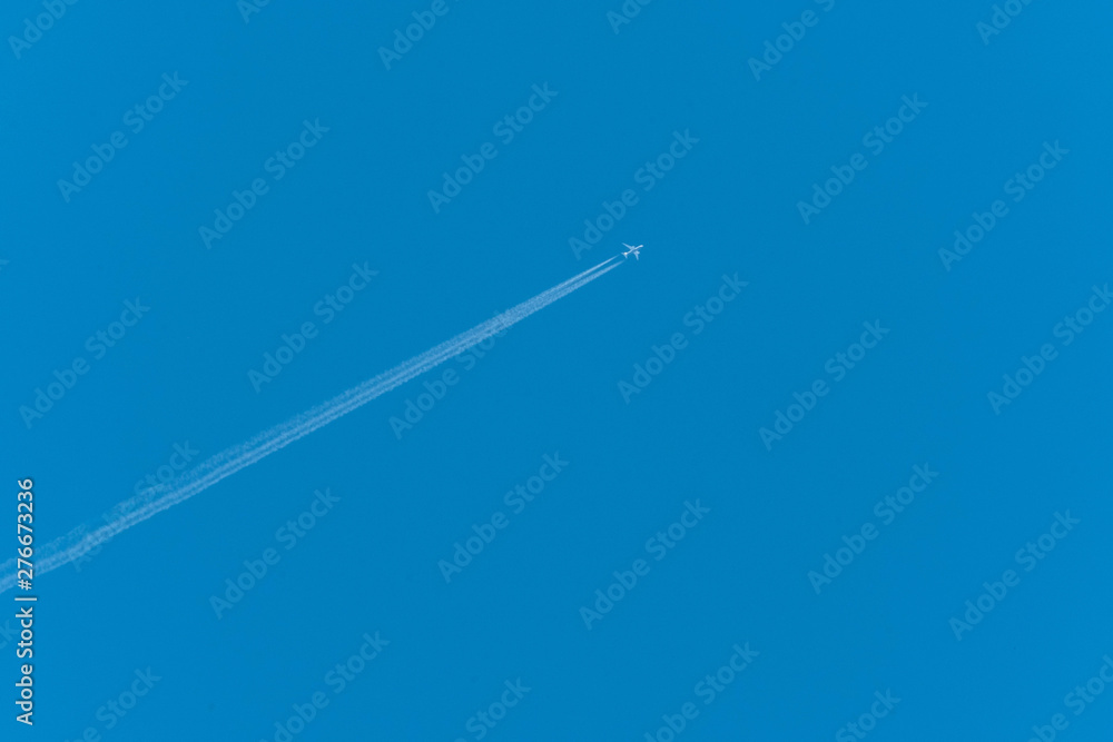 Jet airliner flying high in the sky leaves contrails in the clear blue sky Jet airliner flying high in the sky leaves contrails in the clear blue sky