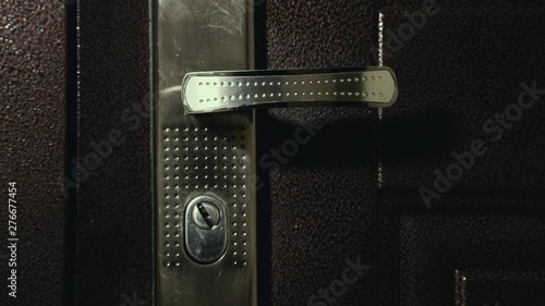 the door handle turns aggressively as if door is forcing by robber, close up