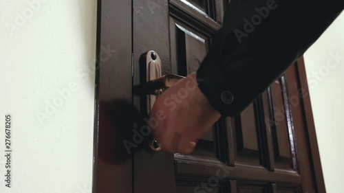 a man in a black leather jacket opens the door with a key and enters inside