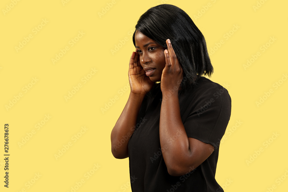 Young african-american woman isolated on yellow studio background, facial expression. Beautiful female half-length portrait. Concept of human emotions, facial expression. Suffering from headache. Young african-american woman isolated on yellow studio background, facial expression. Beautiful female half-length portrait. Concept of human emotions, facial expression. Suffering from headache.