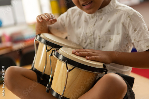 Schoolboy playing bongo in a classroom