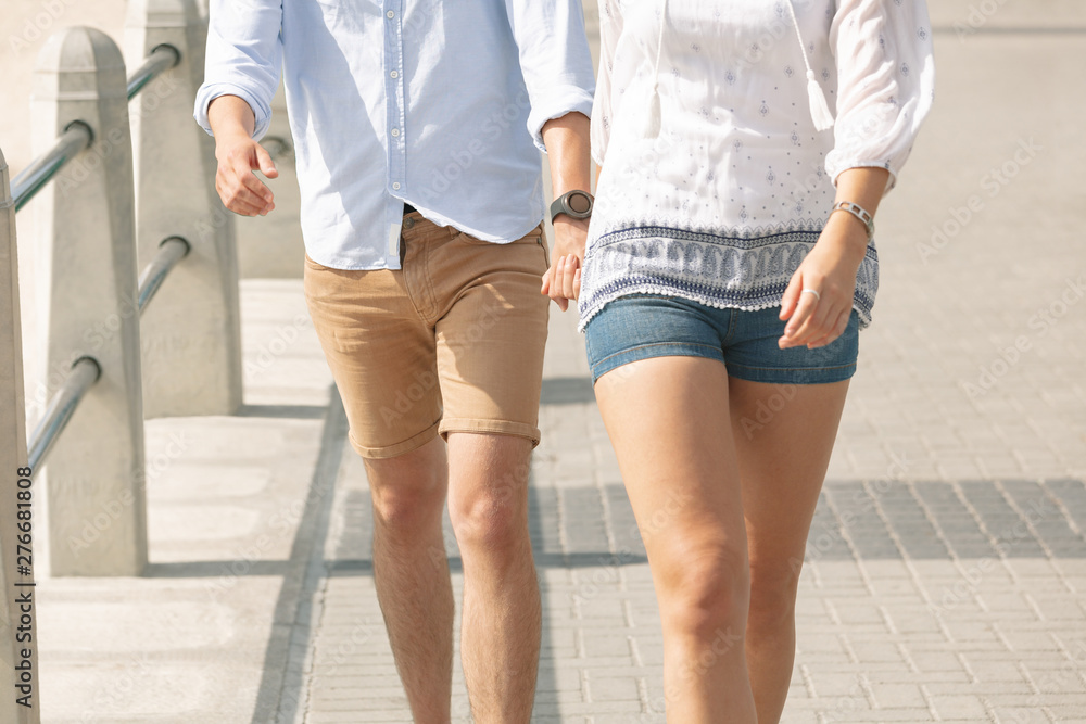 Caucasian couple walking on the promenade at the seaside