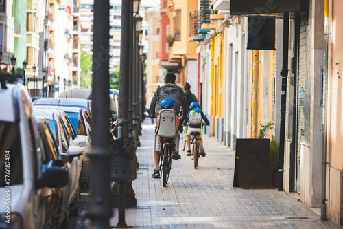 Wallpaper Mural Father carrying his daughter or son on a bicycle going to school or for leisure in a sustainable way on bike Torontodigital.ca