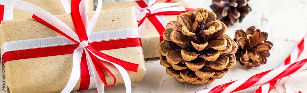 Banner of Christmas or New Year decorations background with pine cones, fir branches, gift boxes, and candy canes Banner of Christmas or New Year decorations background with pine cones, fir branches, gift boxes, and candy canes