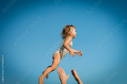 little girl flies through the air and daddy's hands