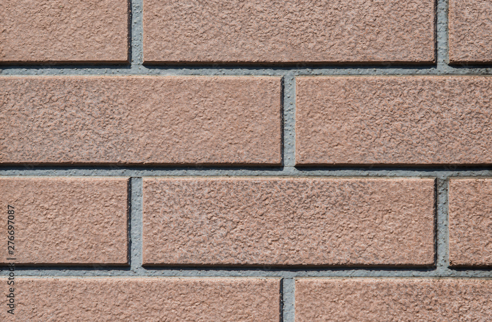 Obraz premium Brown rectangular tiles wall with rough surface as background