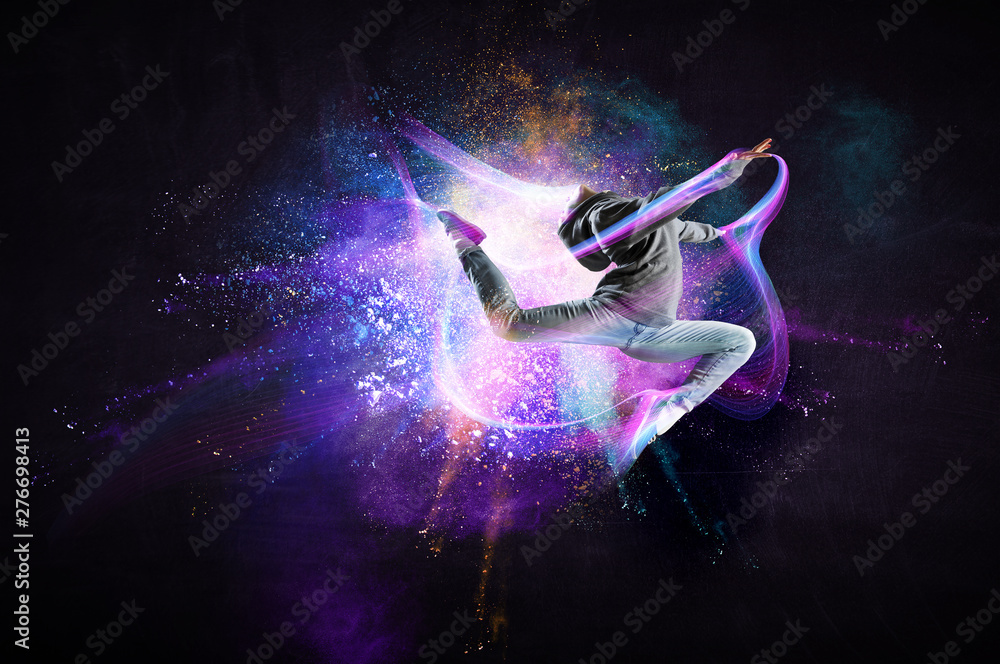 Modern female dancer jumping in hoodie with colourful splashes background. Mixed media - obrazy, fototapety, plakaty 