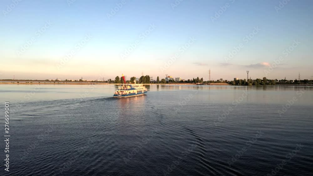 Aerial drone tracking shot of a white and blue cruise ferry boat ship sailing across the river in Kiev, Ukraine Aerial drone tracking shot of a white and blue cruise ferry boat ship sailing across the river in Kiev, Ukraine