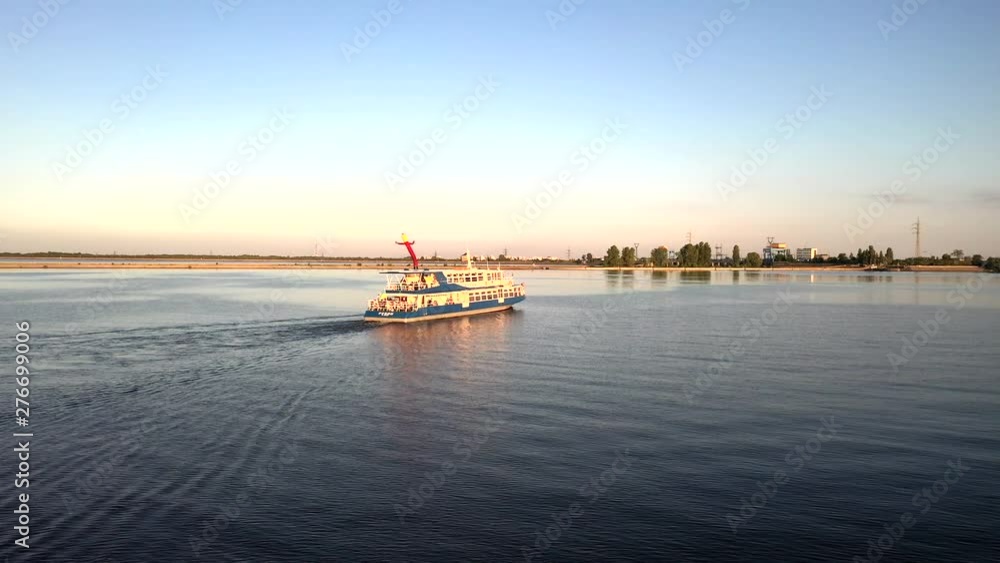 Aerial drone tracking shot of a white and blue cruise ferry boat ship sailing across the river in Kiev, Ukraine Aerial drone tracking shot of a white and blue cruise ferry boat ship sailing across the river in Kiev, Ukraine