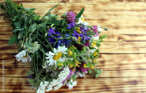Bouquet of wild flowers on wooden background