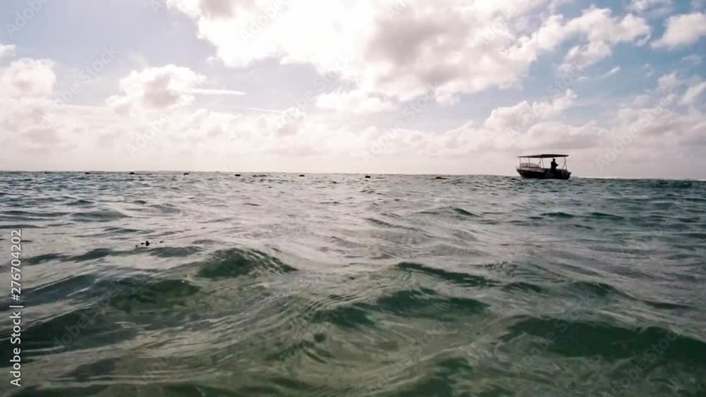 Going from under water, to above water with a view of a boat and endless sea towards the horizon. Going from under water, to above water with a view of a boat and endless sea towards the horizon.