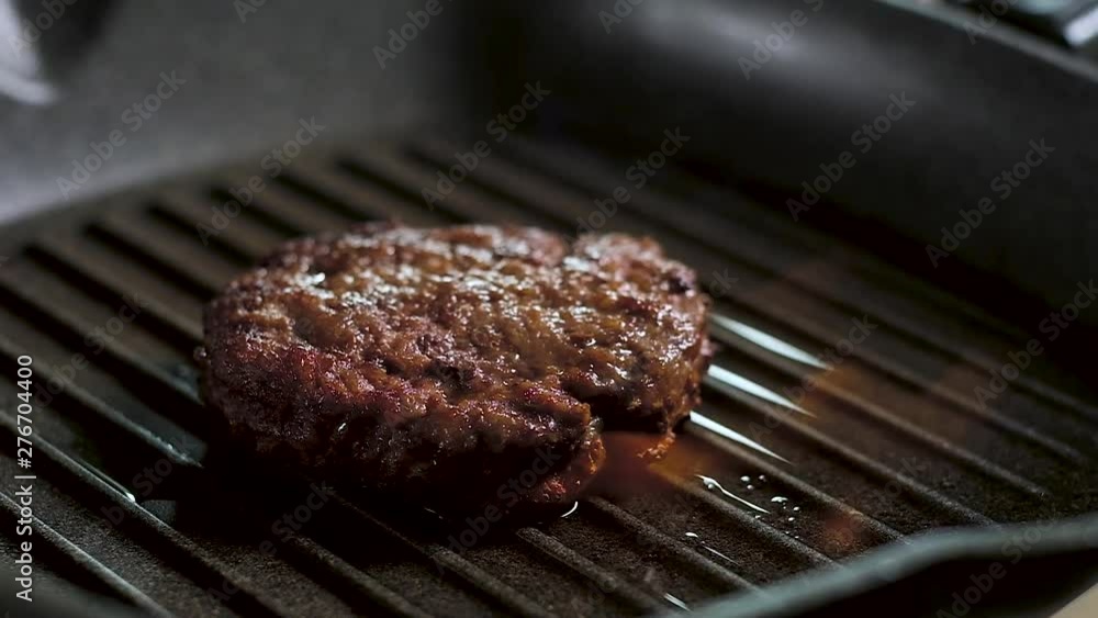 hot tasty juicy fried meat Burger Patty with crispy brown crust, lies on the grill pan in a bright flame. Slow motion cooking meat in the flambé in the kitchen. camera depart back hot tasty juicy fried meat Burger Patty with crispy brown crust, lies on the grill pan in a bright flame. Slow motion cooking meat in the flambé in the kitchen. camera depart back