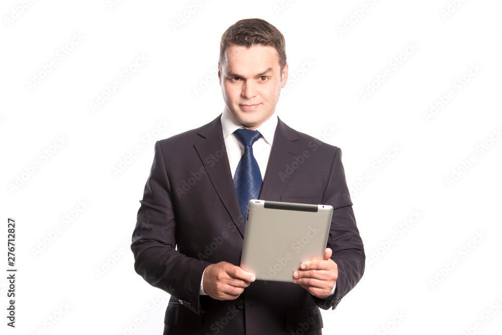 Cute man in a suit with a tablet in his hands is standing on a white background in the studio. Cute man in a suit with a tablet in his hands is standing on a white background in the studio.