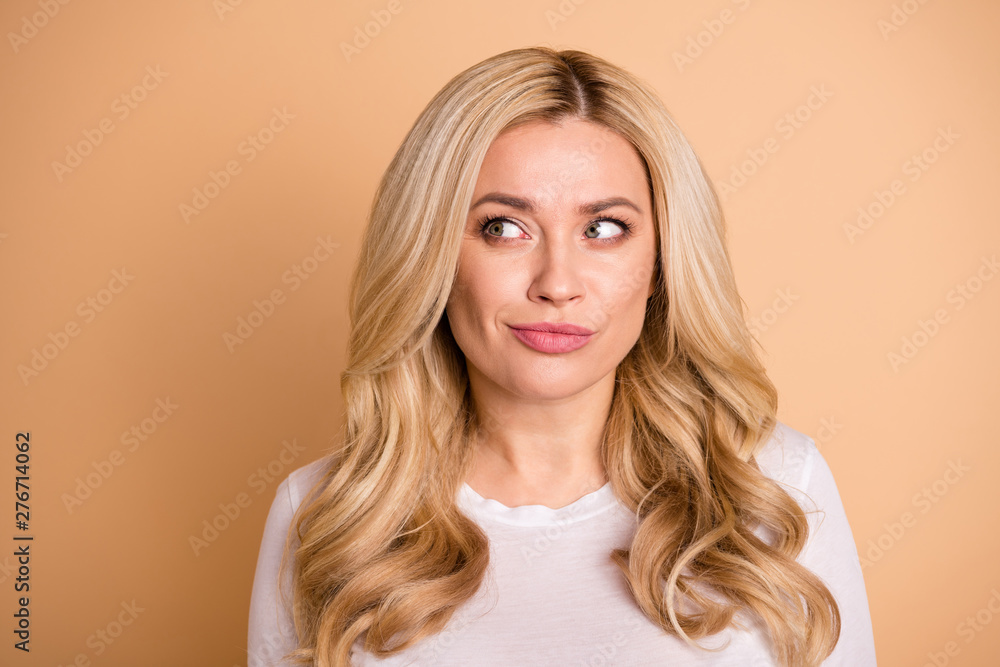 Fototapeta premium Close up photo amazing beautiful she her lady perfect ideal appearance look side empty space interested banner placard shopping prices wear casual white t-shirt isolated beige pastel background