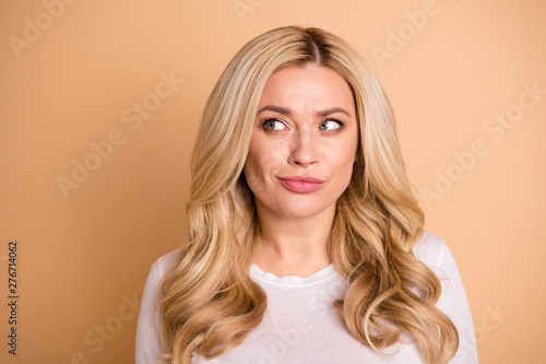 Close up photo amazing beautiful she her lady perfect ideal appearance look side empty space interested banner placard shopping prices wear casual white t-shirt isolated beige pastel background