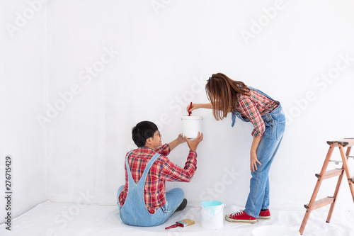 young asian couple in yom-bear and plaids shirts in concept couple help painting a new color the room renovation