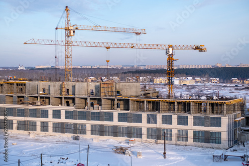 winter season tower cranes on the construction of a large building