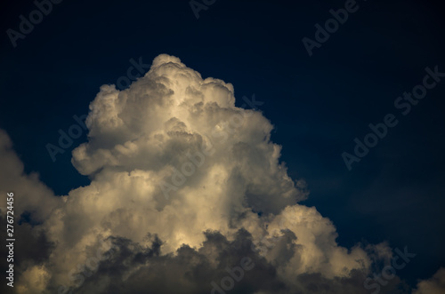 Dramatic night sky with cumulus clouds in moonlight