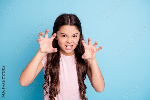 Portrait of evil small naughty kid like wild animal show teeth have fun joy funky funny cute dressed fashionable clothing isolated on blue background photo