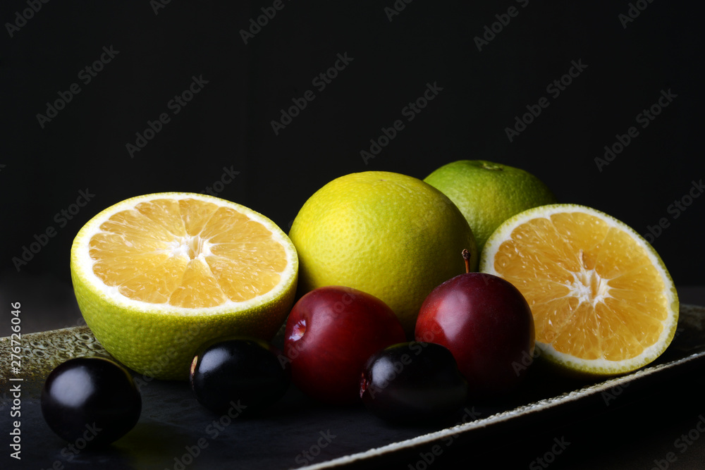 Juicy Sweet lemon, a citrus fruit with ripe plum fruits on table Juicy Sweet lemon, a citrus fruit with ripe plum fruits on table