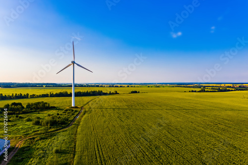 Amazing landscape in summer. Blue sky above farmlands. Producing electricity concept. Wind turbine in field