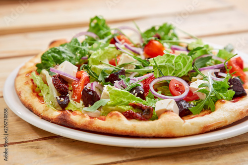 vegetarian pizza with fresh tomatoes, olives, tofu and red onion