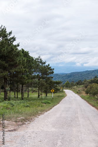 Dirt road along the hill with the traffic sign.