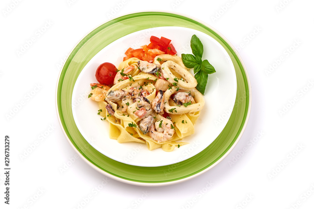 Italian Tagliatelle pasta with shrimp, shellfish and cream sauce, restaurant dish, top view, isolated on white background