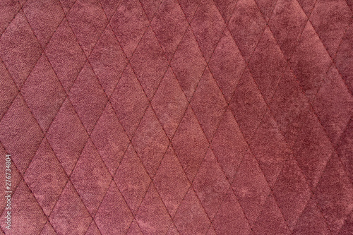 The structure of purple velor fabric. Modern upholstered velvet furniture. Creative vintage background. Quilted fabric.