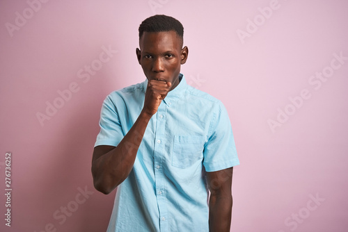 African american man wearing blue casual shirt standing over isolated pink background feeling unwell and coughing as symptom for cold or bronchitis. Healthcare concept.