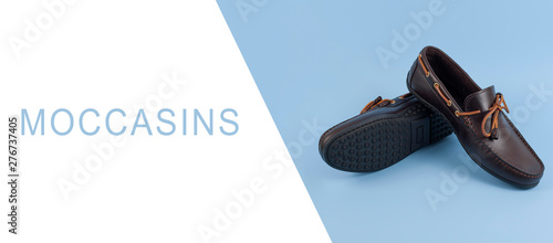 Pair of stylish moccasins on blue background, free space for text
