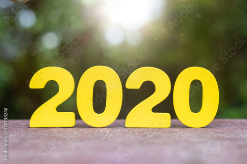 Wooden handmade 2020 numbers on table with blurred tree background