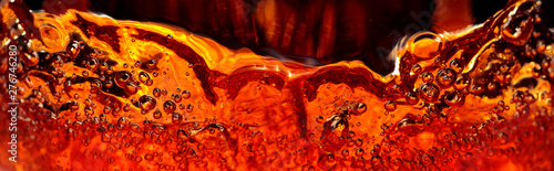 Fotografia, Obraz Alcoholic drink on a dark background, abstract splashing.