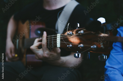 Man’s hands playing acoustic guitar, close up. Travel, tourism leisure time concept.