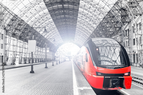 Fototapeta wnętrze dworca kolejowego szeroki widok historycznego transportu kolejowego budynku w Moskwie Rosja z nowoczesnym pociągiem przybywającym na platformę czarno-białe retro stylizowane tło