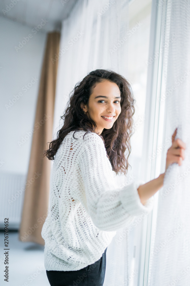 People and hope concept. Happy woman opening window curtains People and hope concept. Happy woman opening window curtains