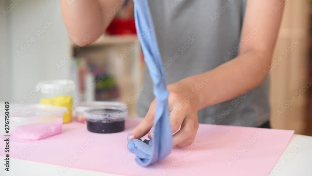 child play with blue slime. playing with slime.	