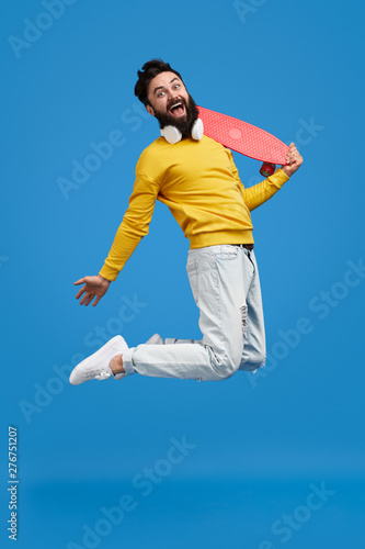 Excited man with skateboard leaping up