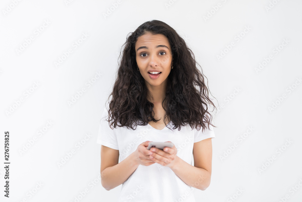 Portrait of smiling casual woman holding smartphone over white background Portrait of smiling casual woman holding smartphone over white background