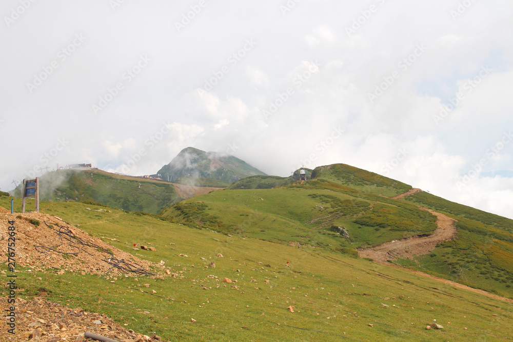 Naklejka premium Green mountains and clouds