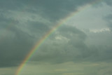 rainbow, atmospheric natural phenomenon, against a background of gray rain clouds