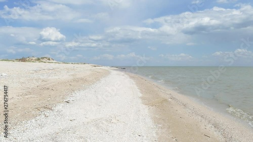 Deserted beach on the shore. The shining sky