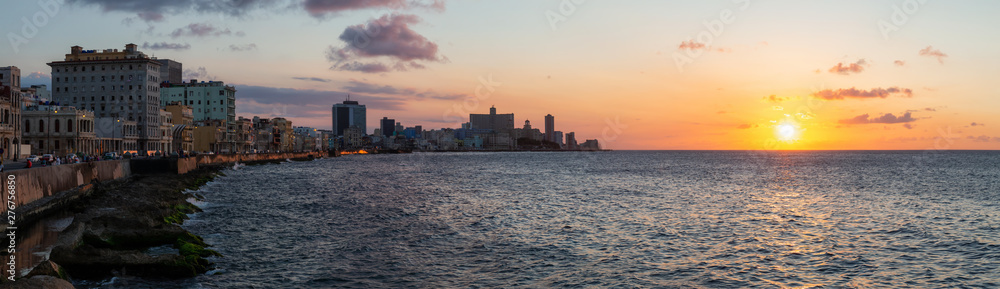 Beautiful Panoramic view of the Old Havana City, Capital of Cuba, by the ocean coast during a vibrant cloudy sunset. Beautiful Panoramic view of the Old Havana City, Capital of Cuba, by the ocean coast during a vibrant cloudy sunset.