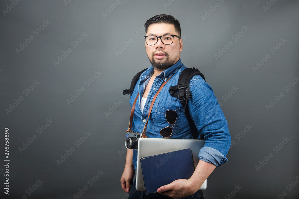 A mature man carries his schoolbag and equipment to travel. A mature man carries his schoolbag and equipment to travel.