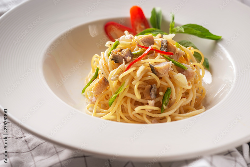 Salted fish spaghetti served in a white dish