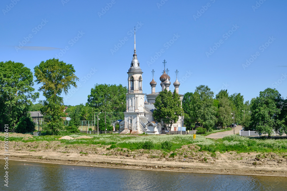 Scenic view of old small church on bank of river in ancient touristic town Vologda in Russian Federation. Beautiful summer sunny look of orthodox temple in urban area of capital of russian province
