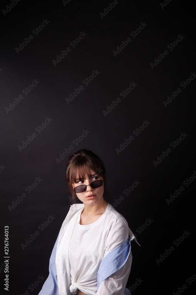 Caucasian Girl in white shirt with black sunglasses posing in the studio Caucasian Girl in white shirt with black sunglasses posing in the studio
