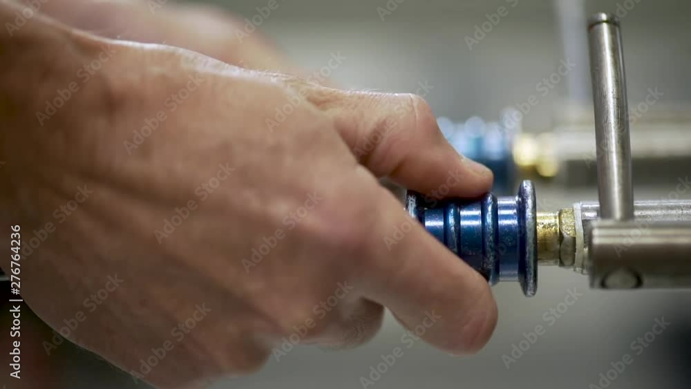 Worker's hands testing gears with high pressure machine Worker's hands testing gears with high pressure machine