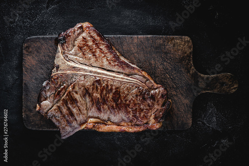 Barbecue Grilled Dry Aged Beef T-bone Steak on Rustic Cutting Board photo